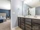 Bright bathroom with double vanity, dark wood cabinets, and a view into the Primary bedroom at 9123 Magnolia Lily Ave, Charlotte, NC 28227