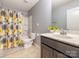 Bathroom featuring a vanity with dark cabinets, a bathtub with shower, and floral accents at 9123 Magnolia Lily Ave, Charlotte, NC 28227