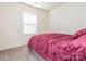 Simple bedroom featuring a comfy bed with a red velvet comforter and a window at 9123 Magnolia Lily Ave, Charlotte, NC 28227