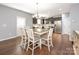 Inviting dining area with wood floors, a stylish table, and a view of the modern kitchen at 9123 Magnolia Lily Ave, Charlotte, NC 28227