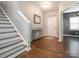 Welcoming entryway featuring hardwood floors, a console table, and a staircase with carpeted steps at 9123 Magnolia Lily Ave, Charlotte, NC 28227