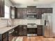 Modern kitchen with stainless steel appliances, granite countertops, and dark wood cabinetry and flooring at 9123 Magnolia Lily Ave, Charlotte, NC 28227