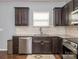 A view of the kitchen featuring stainless steel appliances, granite countertops, and dark wood cabinetry at 9123 Magnolia Lily Ave, Charlotte, NC 28227