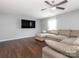 Bright living area featuring hardwood floors, a large TV, and comfortable sectional sofa at 9123 Magnolia Lily Ave, Charlotte, NC 28227