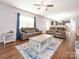 Bright and spacious living room with hardwood floors, featuring two sofas, a ceiling fan, and an open layout at 9123 Magnolia Lily Ave, Charlotte, NC 28227
