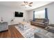 Cozy living room with hardwood floors, a ceiling fan, and comfortable seating area for relaxing or entertaining at 9123 Magnolia Lily Ave, Charlotte, NC 28227