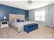 Serene main bedroom with a decorative blue accent wall and large upholstered headboard at 9123 Magnolia Lily Ave, Charlotte, NC 28227