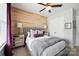 Bedroom featuring wood accent wall, neutral tones, and mirrored bedside tables at 956 Herrons Ferry Rd, Rock Hill, SC 29730