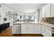 Open-concept kitchen with granite island and stainless steel dishwasher, with view into the living room and wood floors at 956 Herrons Ferry Rd, Rock Hill, SC 29730