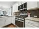 Modern kitchen featuring stainless steel appliances, granite countertops and white cabinetry, with wood flooring and gray backsplash at 956 Herrons Ferry Rd, Rock Hill, SC 29730