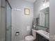 Clean bathroom with shower and glass door, featuring a modern sink, toilet, and light gray walls at 1005 Noles Dr, Mount Holly, NC 28120