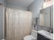 Functional bathroom featuring a shower with curtain, tiled walls, a toilet and a vanity with a sink at 1005 Noles Dr, Mount Holly, NC 28120