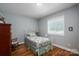 Cozy bedroom featuring hardwood floors, a metal bed frame, and window with natural light for a serene space at 1005 Noles Dr, Mount Holly, NC 28120