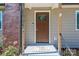 Inviting front porch with a decorative front door and landscaped surroundings at 1005 Noles Dr, Mount Holly, NC 28120