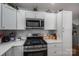 Modern kitchen features stainless steel appliances, white cabinets, and quartz countertops for efficient cooking at 1005 Noles Dr, Mount Holly, NC 28120