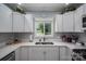 Bright, renovated kitchen featuring stainless steel appliances and white cabinetry, providing ample storage and a modern touch at 1005 Noles Dr, Mount Holly, NC 28120