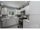 Well-lit kitchen featuring stainless steel appliances, quartz countertops, and white cabinetry, creating a modern aesthetic at 1005 Noles Dr, Mount Holly, NC 28120
