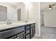 Bathroom featuring a double sink vanity and doorway to an adjacent bedroom at 10304 Ebbets Rd, Charlotte, NC 28273