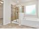 Bright bathroom featuring a bathtub, a glass-enclosed shower, and tile flooring at 10304 Ebbets Rd, Charlotte, NC 28273