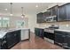 Modern kitchen with stainless steel appliances, black cabinetry, and a view into the dining area at 10304 Ebbets Rd, Charlotte, NC 28273