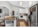 Well-lit kitchen with island seating, stainless steel appliances, and white cabinets at 106 Abbey Cir, Salisbury, NC 28147