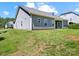 Well-maintained backyard featuring a home with gray siding, a lush lawn, and a covered porch at 117 Autumn Mist Rd, Statesville, NC 28677
