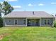 Inviting backyard features a covered patio with a cozy hanging chair and a view of the lush lawn at 117 Autumn Mist Rd, Statesville, NC 28677