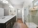 Well-lit bathroom featuring a double sink vanity, tile flooring, and a glass-enclosed shower at 117 Autumn Mist Rd, Statesville, NC 28677