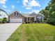 Beautiful single-story home with a well-manicured lawn, stone accents, and attached garage at 117 Autumn Mist Rd, Statesville, NC 28677