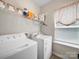 Functional laundry room featuring white appliances, shelving, and a window with natural light at 117 Autumn Mist Rd, Statesville, NC 28677