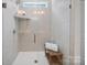 Tiled walk-in shower with glass door, built-in shelving, and a comfortable bench at 117 Autumn Mist Rd, Statesville, NC 28677