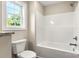 Bright bathroom featuring tub and shower combo, vinyl floor and a window at 1234 Goodnight Ln, Kannapolis, NC 28081