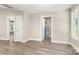 Open bedroom view with wood-look flooring and neutral walls leads to a utility room at 1234 Goodnight Ln, Kannapolis, NC 28081