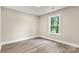 Cozy bedroom boasts new hardwood flooring and ample natural light from a large window at 1234 Goodnight Ln, Kannapolis, NC 28081