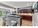 Basement bar featuring dark wood cabinets, counter seating, and a mini fridge at 1399 Verdict Ridge Dr, Denver, NC 28037