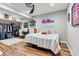 Cozy bedroom with hardwood floors, a bed with striped bedding, a ceiling fan, desk, and Ole Miss decor at 1399 Verdict Ridge Dr, Denver, NC 28037