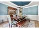 Dining room showcasing blue ceiling and walls along with hardwood floors and seating for eight at 1399 Verdict Ridge Dr, Denver, NC 28037