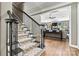 Inviting entryway with a staircase featuring decorative carpet and dark wood banister, leading into the living area at 1399 Verdict Ridge Dr, Denver, NC 28037