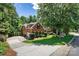 Brick house with a long driveway and a basketball hoop, surrounded by lush greenery and a well-kept lawn at 1399 Verdict Ridge Dr, Denver, NC 28037