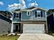 Charming two-story home featuring blue siding, brick accents, a two-car garage, and a well-maintained lawn at 1402 31St Ne St, Conover, NC 28613