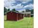 Backyard featuring a red storage shed, brick home exterior, and green lawn at 1901 Taylor Dr, Gastonia, NC 28052