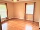 Bedroom with hardwood floors and two windows with blinds and curtains at 1901 Taylor Dr, Gastonia, NC 28052