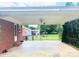Covered patio with ceiling fan, brick accents, and backyard view through a black metal fence at 1901 Taylor Dr, Gastonia, NC 28052
