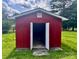 Red shed with white trim and open doors surrounded by grass at 1901 Taylor Dr, Gastonia, NC 28052
