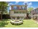 Backyard view of brick home featuring a fire pit with seating and well maintained lawn at 206 Mitchell Ave, Salisbury, NC 28144