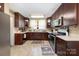 U-shaped kitchen with stainless appliances, white countertops, and dark wood cabinets at 206 Mitchell Ave, Salisbury, NC 28144