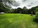 Expansive green backyard features mature trees, providing a serene outdoor space with lush surroundings at 211 Oak Dr, Shelby, NC 28150