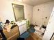 Dilapidated bathroom features a mirror over the sink and toilet with blue rug on a worn floor at 211 Oak Dr, Shelby, NC 28150