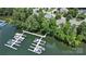 Beautiful aerial view of a private dock with multiple boats on the lake, surrounded by mature trees and lush landscaping at 21319 Baltic Dr, Cornelius, NC 28031