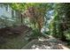 Beautiful home exterior with lush greenery, stone accents, and landscaped walkway to the lake at 21319 Baltic Dr, Cornelius, NC 28031